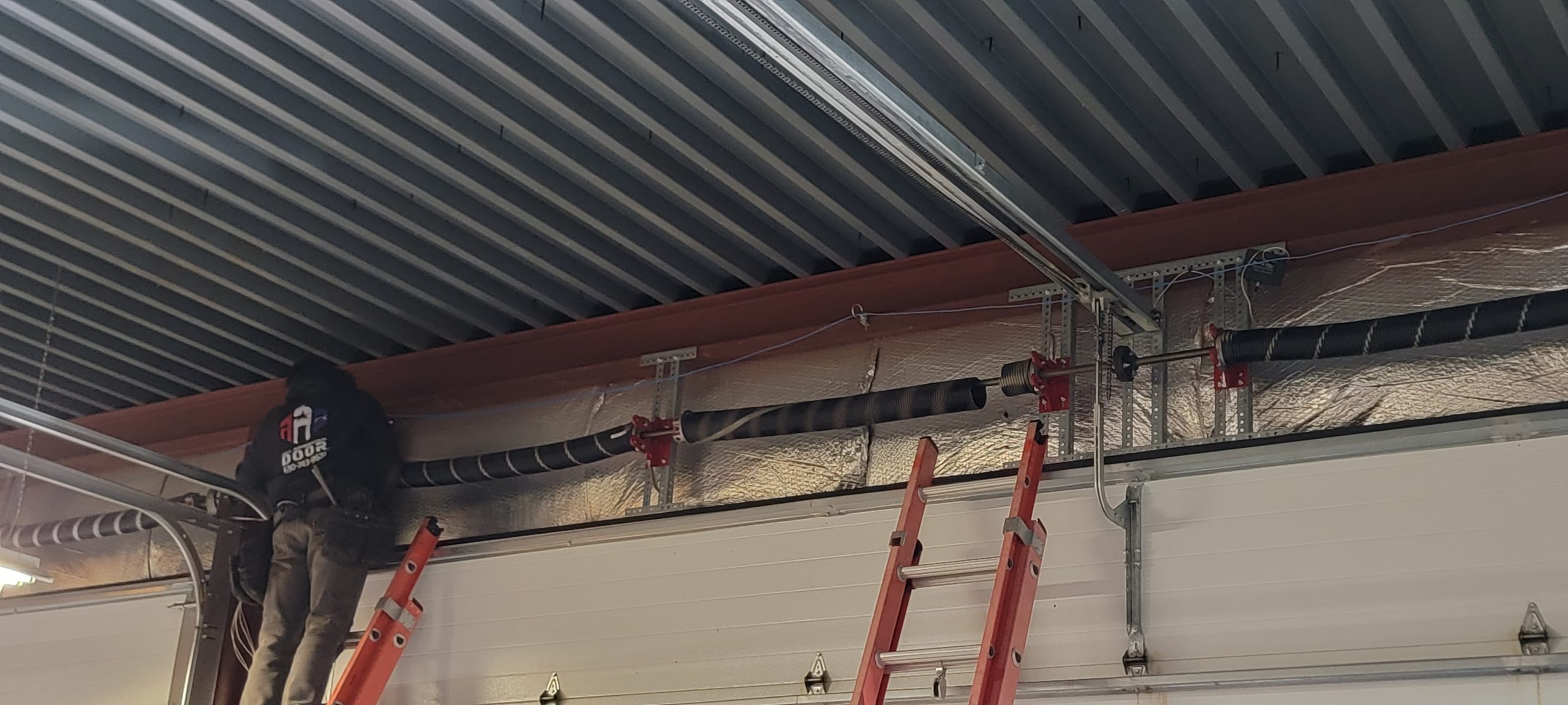 Garage tech working on fixing spring on garage door.